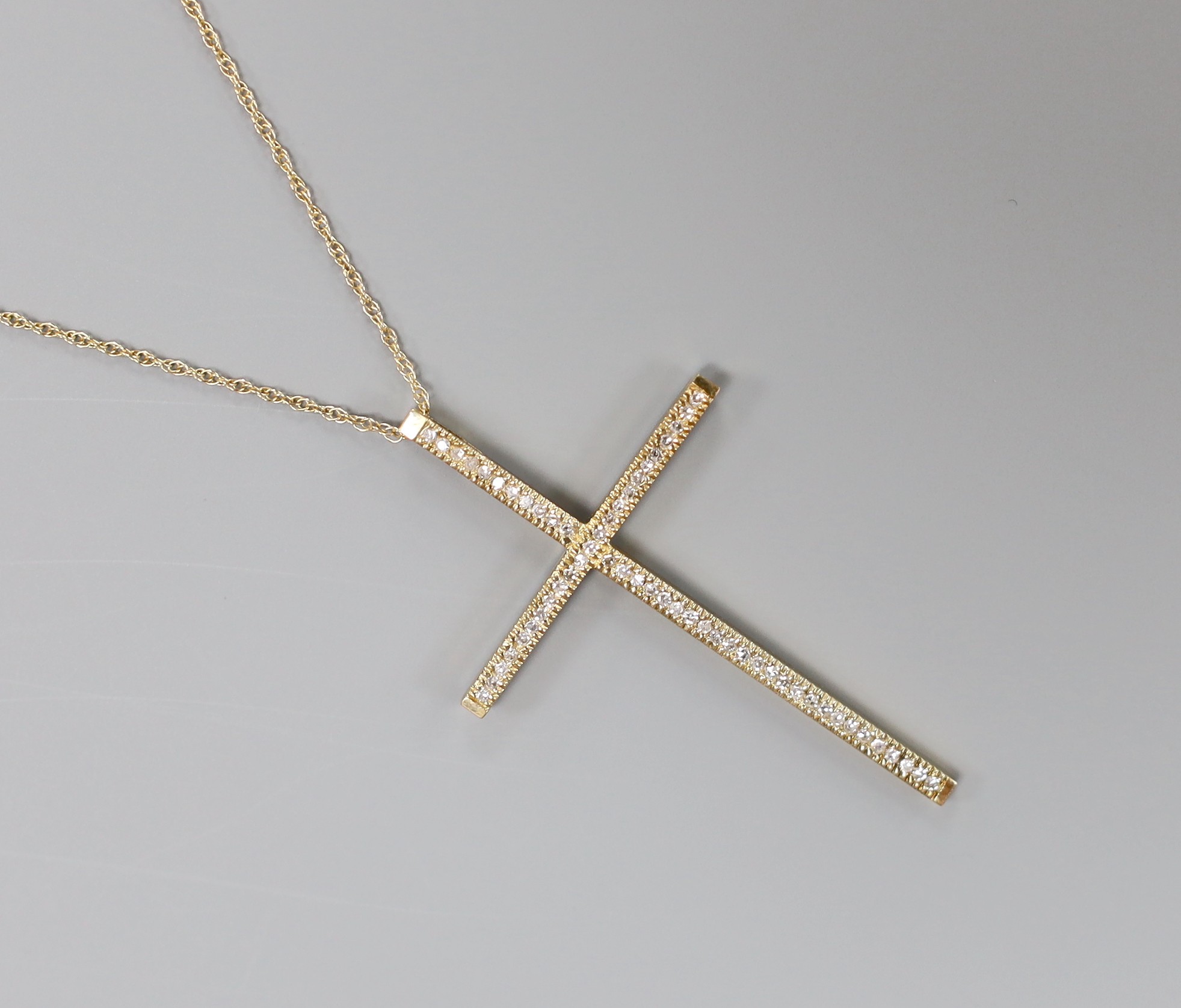 A modern 9ct gold and diamond cluster set cross pendant, 49mm, on a 9k fine link chain, 40cm, gross weight 4 grams.